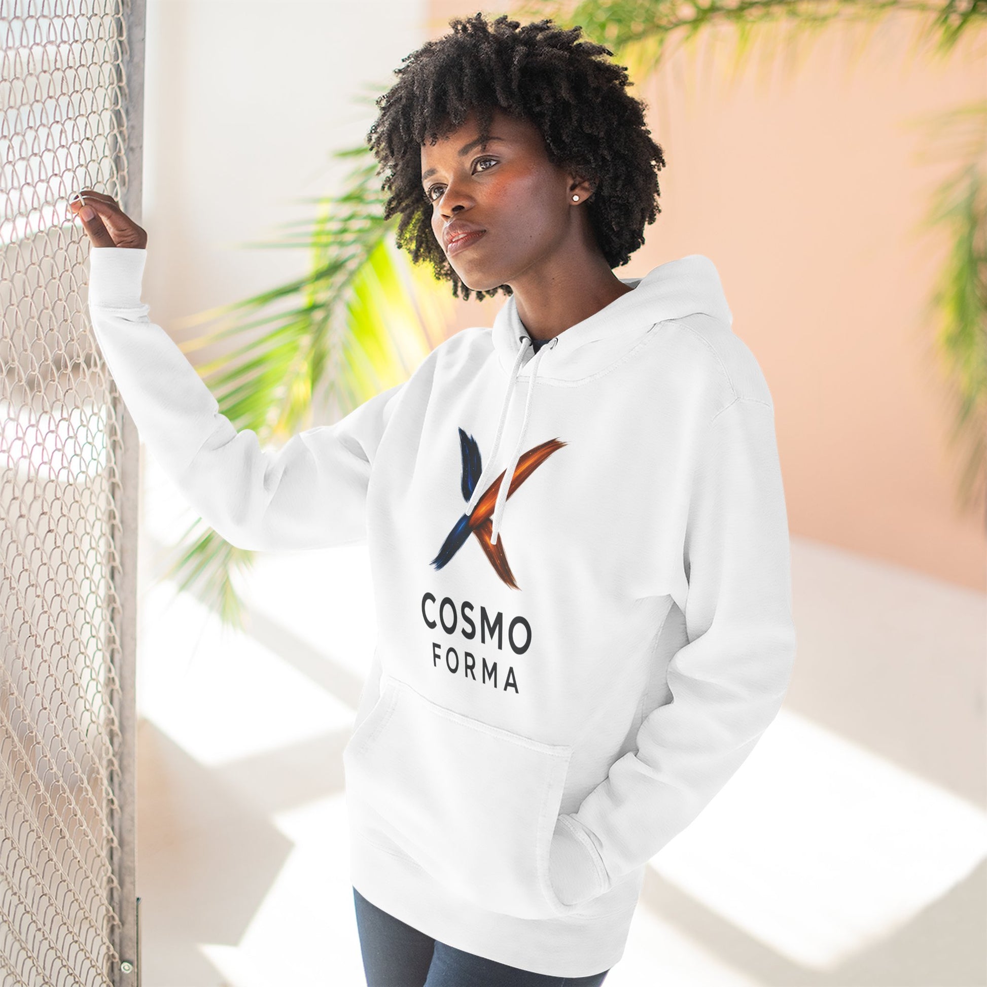 Person wearing a white hoodie with 'Cosmo Forma' logo against a light background