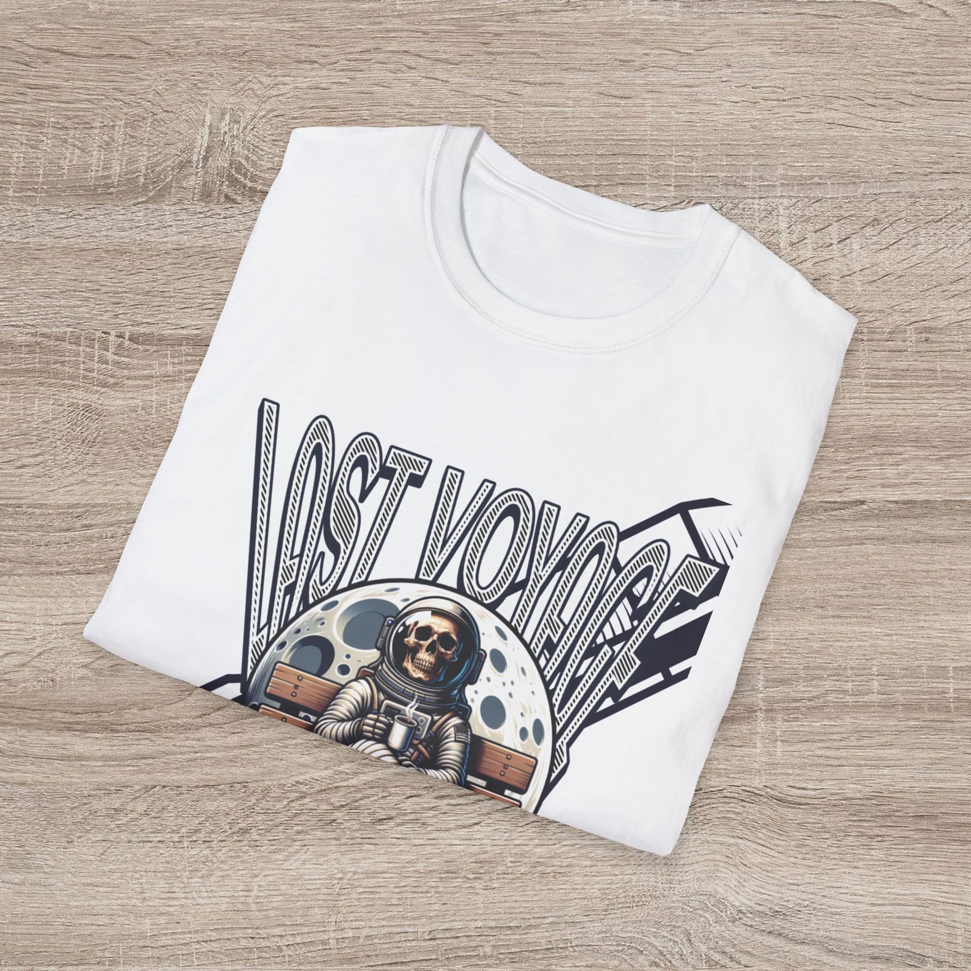 White t-shirt with 'Lost Voyages' design featuring an astronaut and space-themed graphics on a wooden surface.