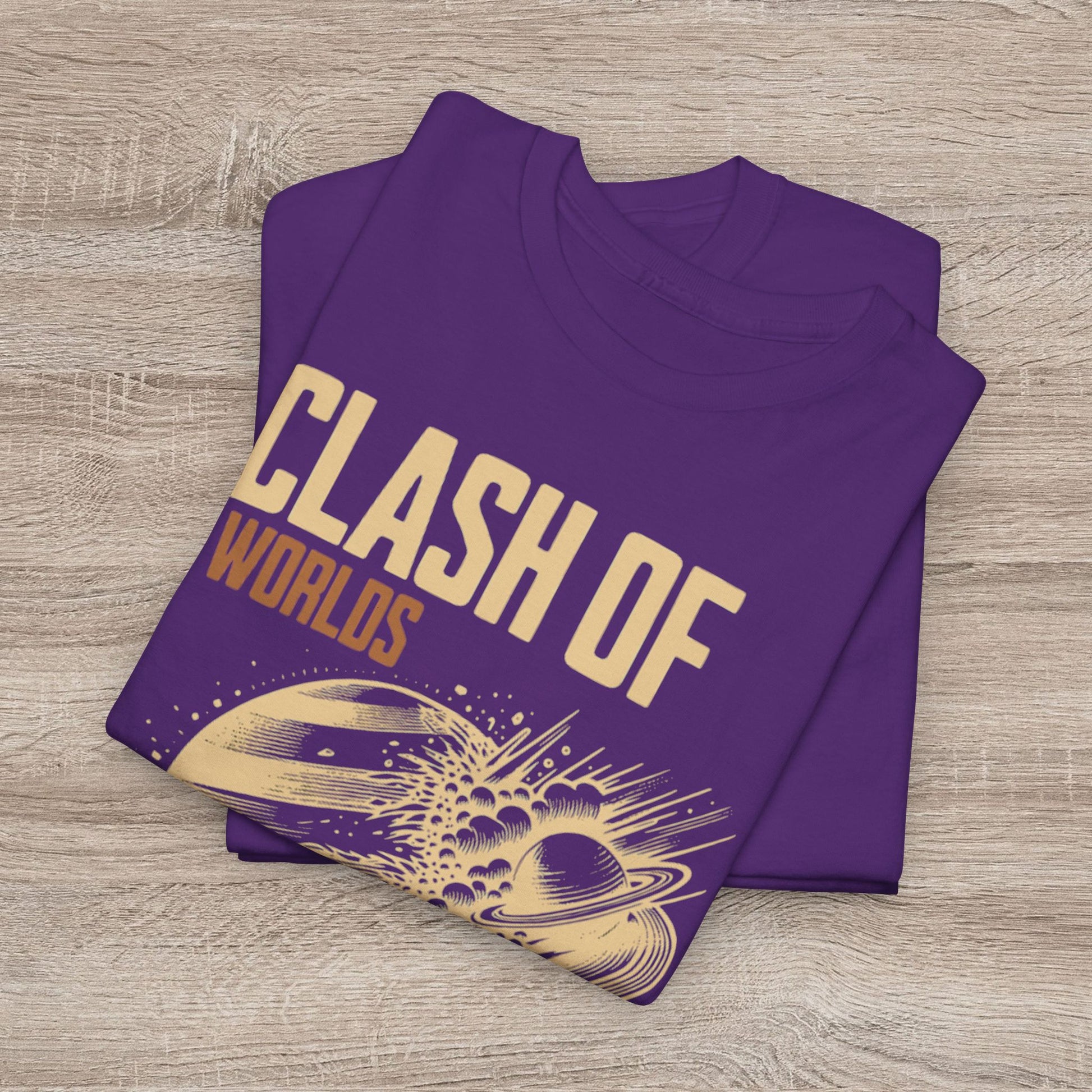 Folded purple t-shirt with 'Clash of Worlds' text and space-themed design on a wooden surface