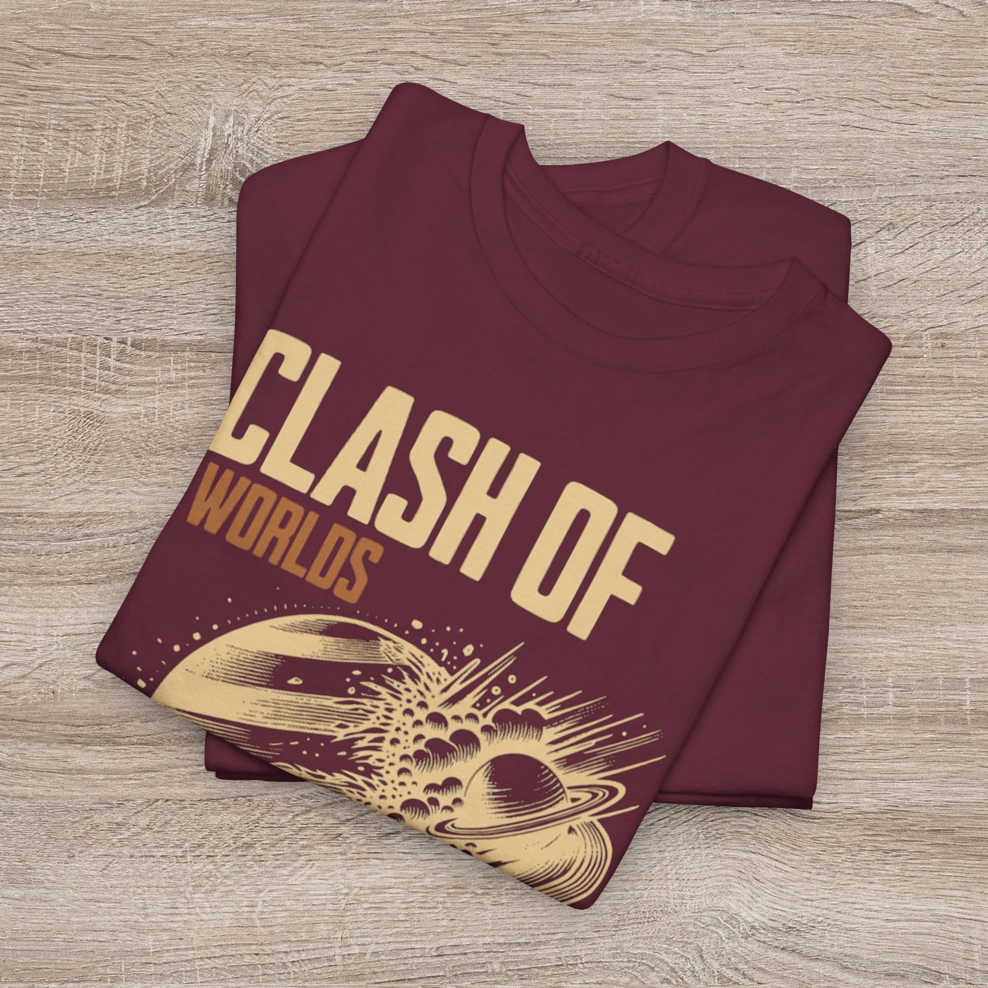 Folded maroon t-shirt with 'Clash of Worlds' design on a wooden surface
