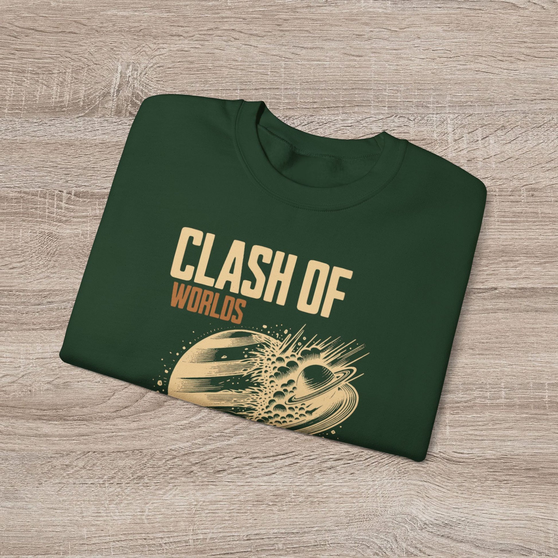 Folded green sweatshirt with 'Clash of Worlds' text and graphic on a wooden surface
