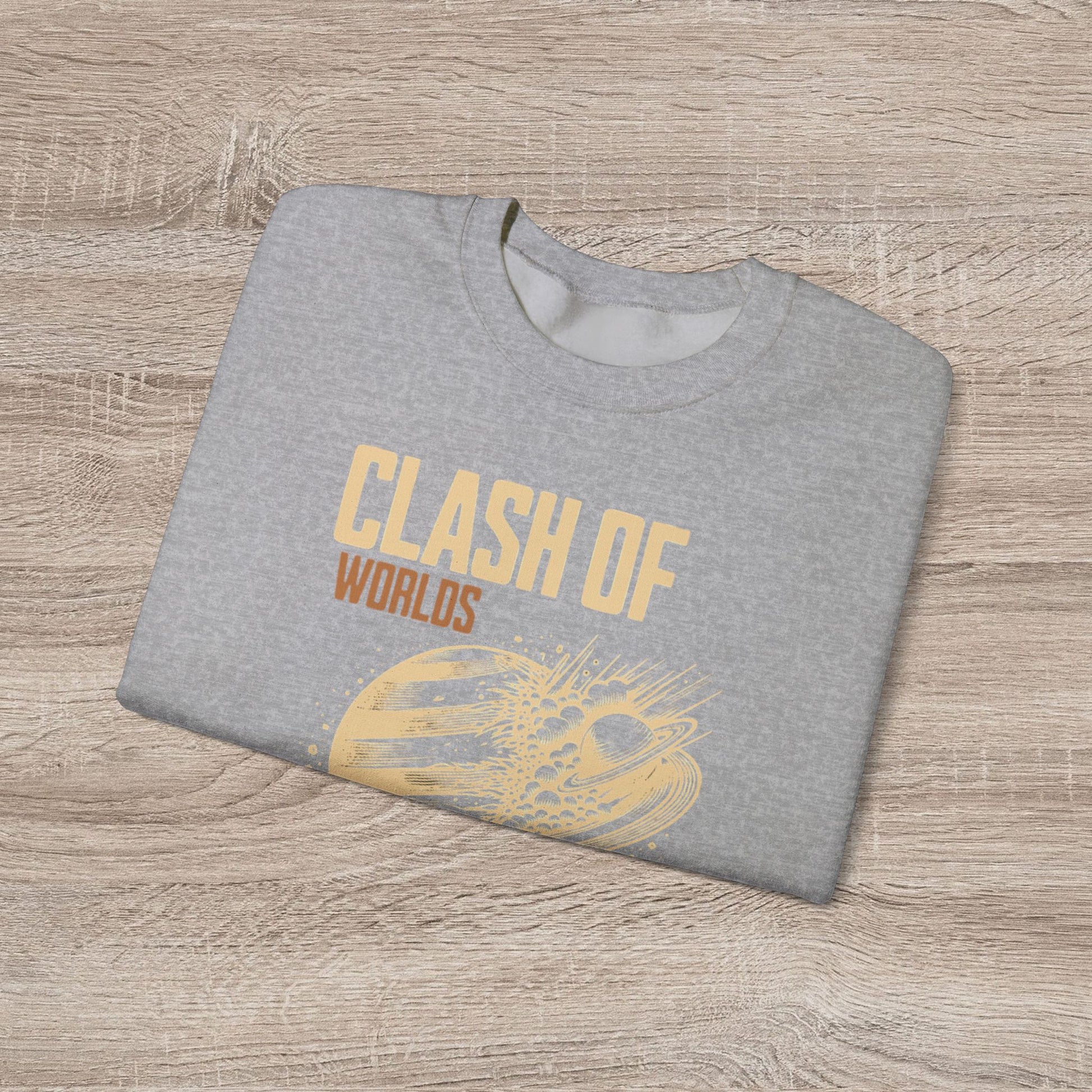 Gray sweatshirt with 'Clash of Worlds' text on a wooden surface