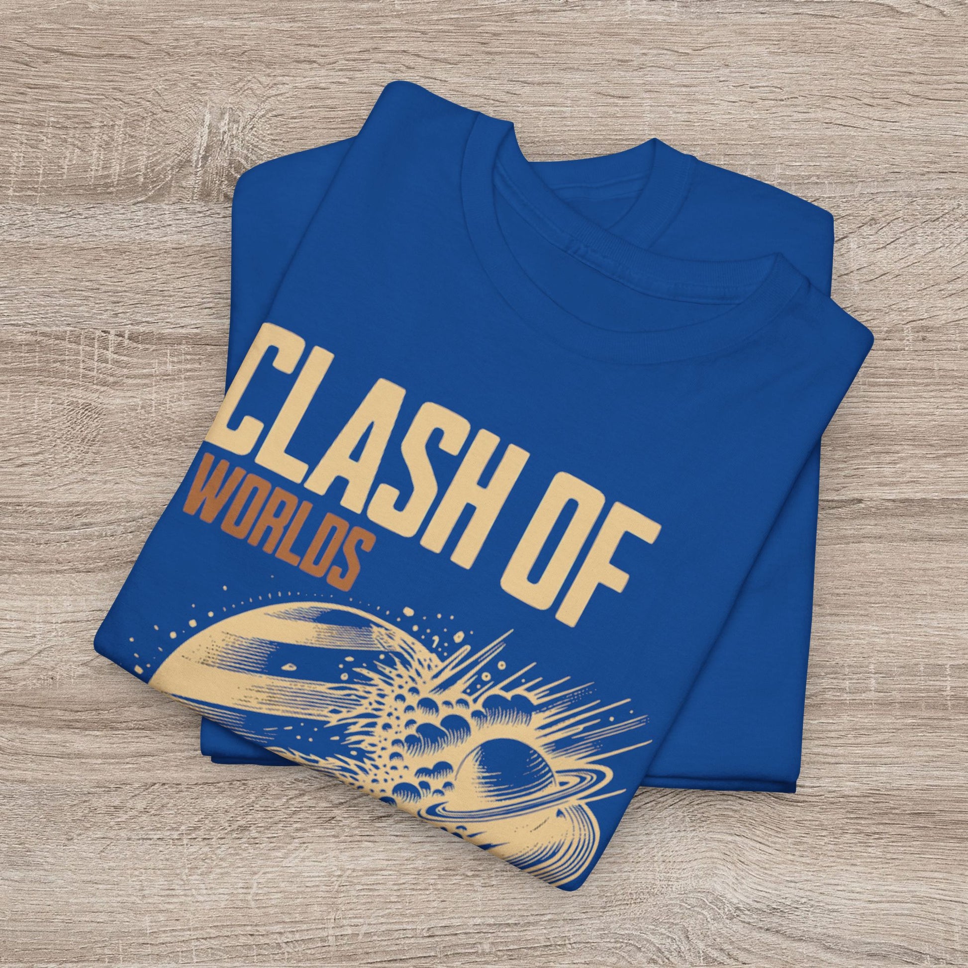 Folded blue t-shirt with 'Clash of Worlds' design on a wooden surface