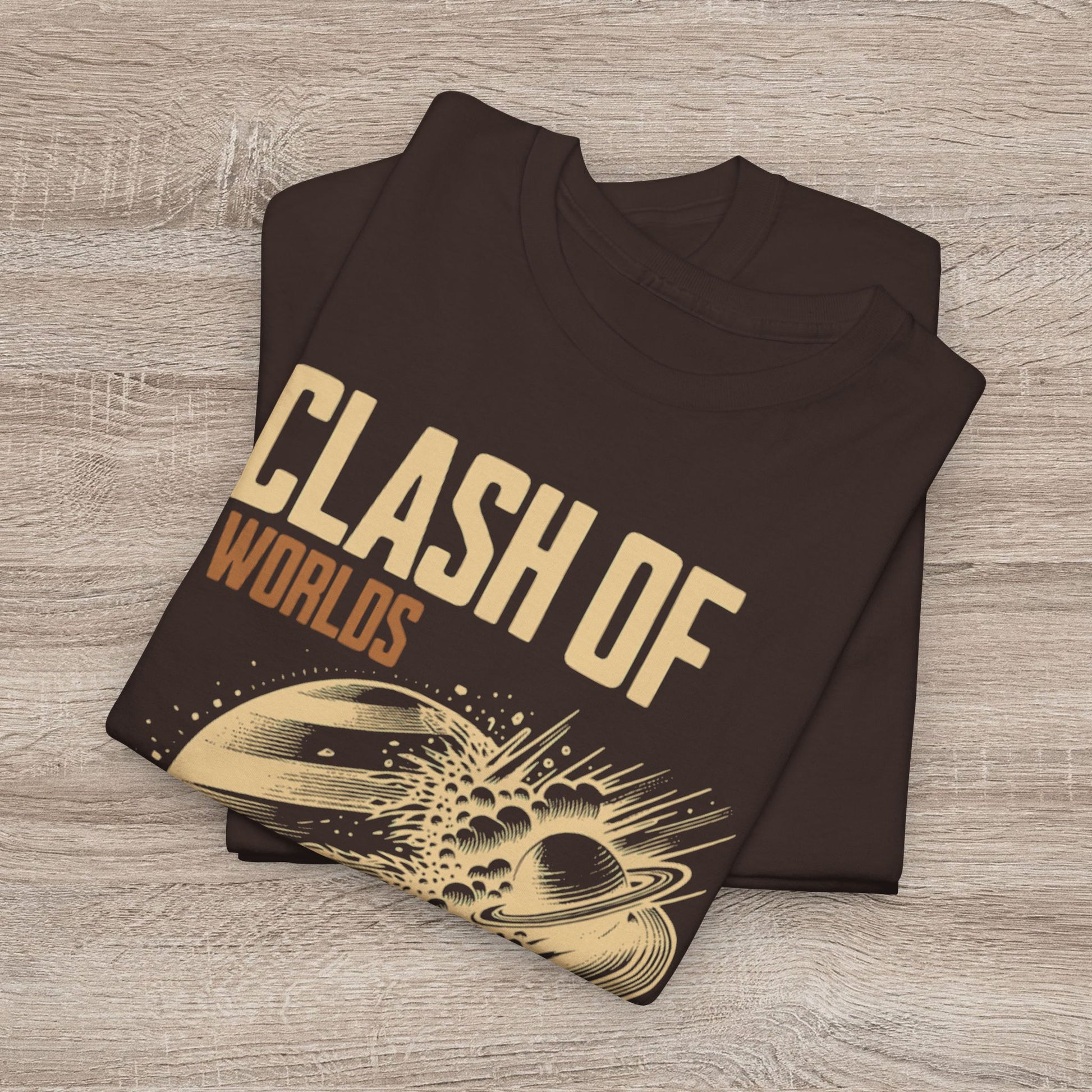 Folded black t-shirt with 'Clash of Worlds' design on a wooden surface